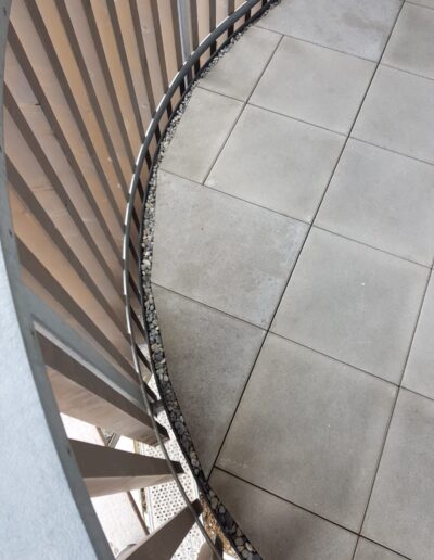 Plattenbelage, Kurvenförmige Terrasse mit Steinrand