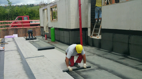 Gussasphaltschutzschicht, Bauarbeiter verlegen Abdichtungsbahn